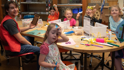 A group of children being led by a volunteer in a facilitated group activity at ScienceWorks