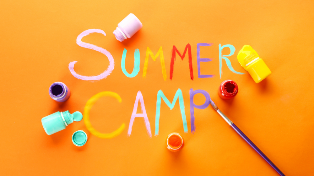 the words summer camp painted on an orange background with small paint pots and brushes scattered ar