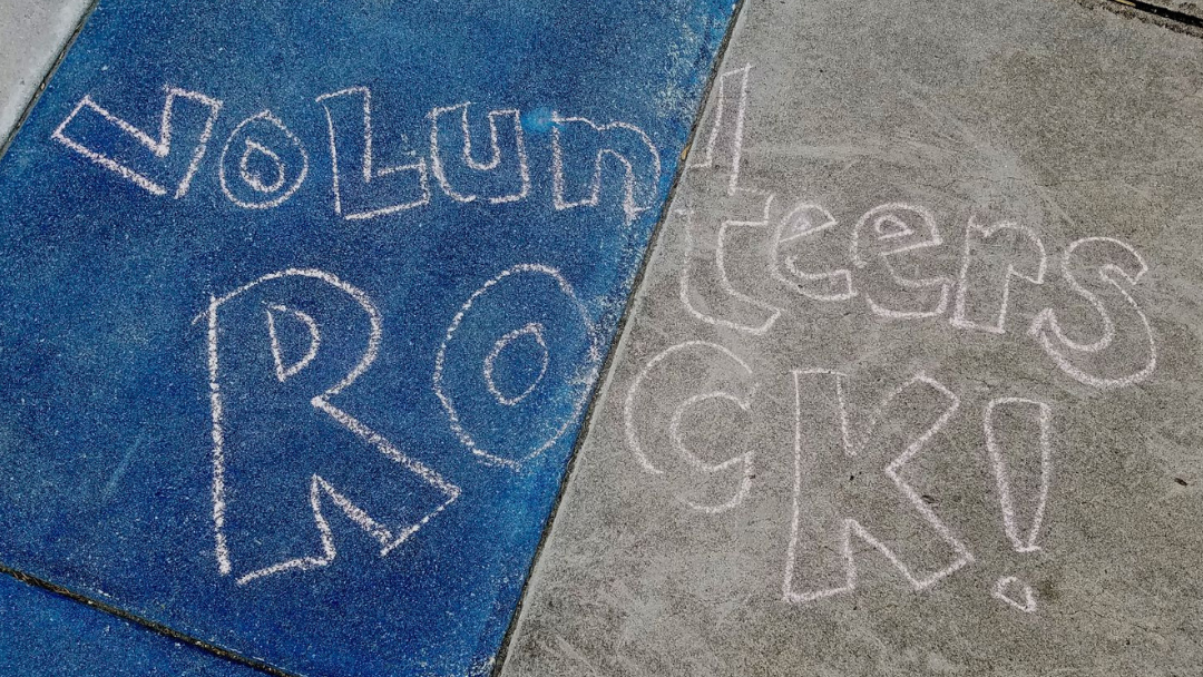 Chalk writing on cement plaza that says, 