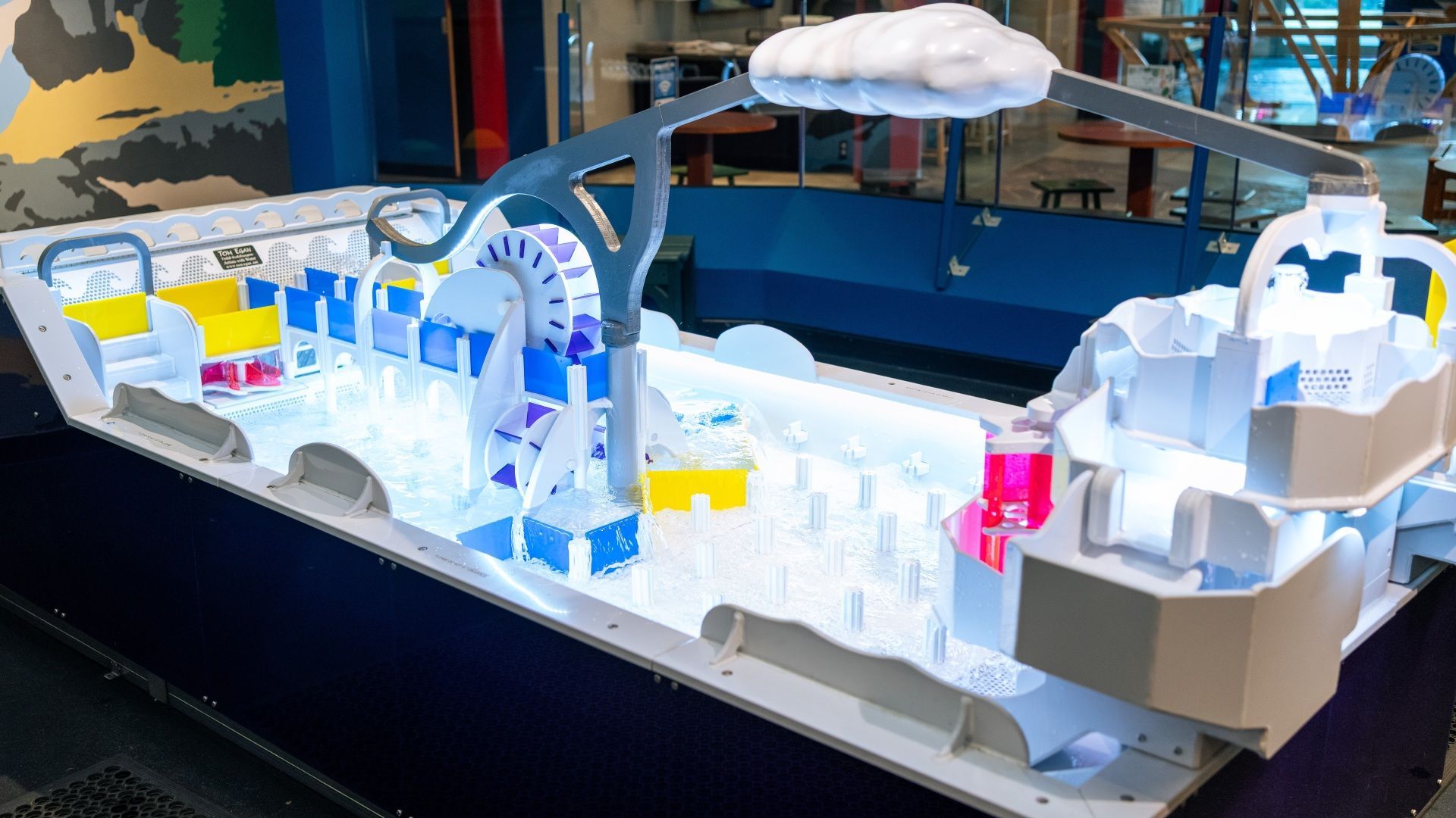 An adult and child using the Wing Zingers exhibit to launch paper airplanes