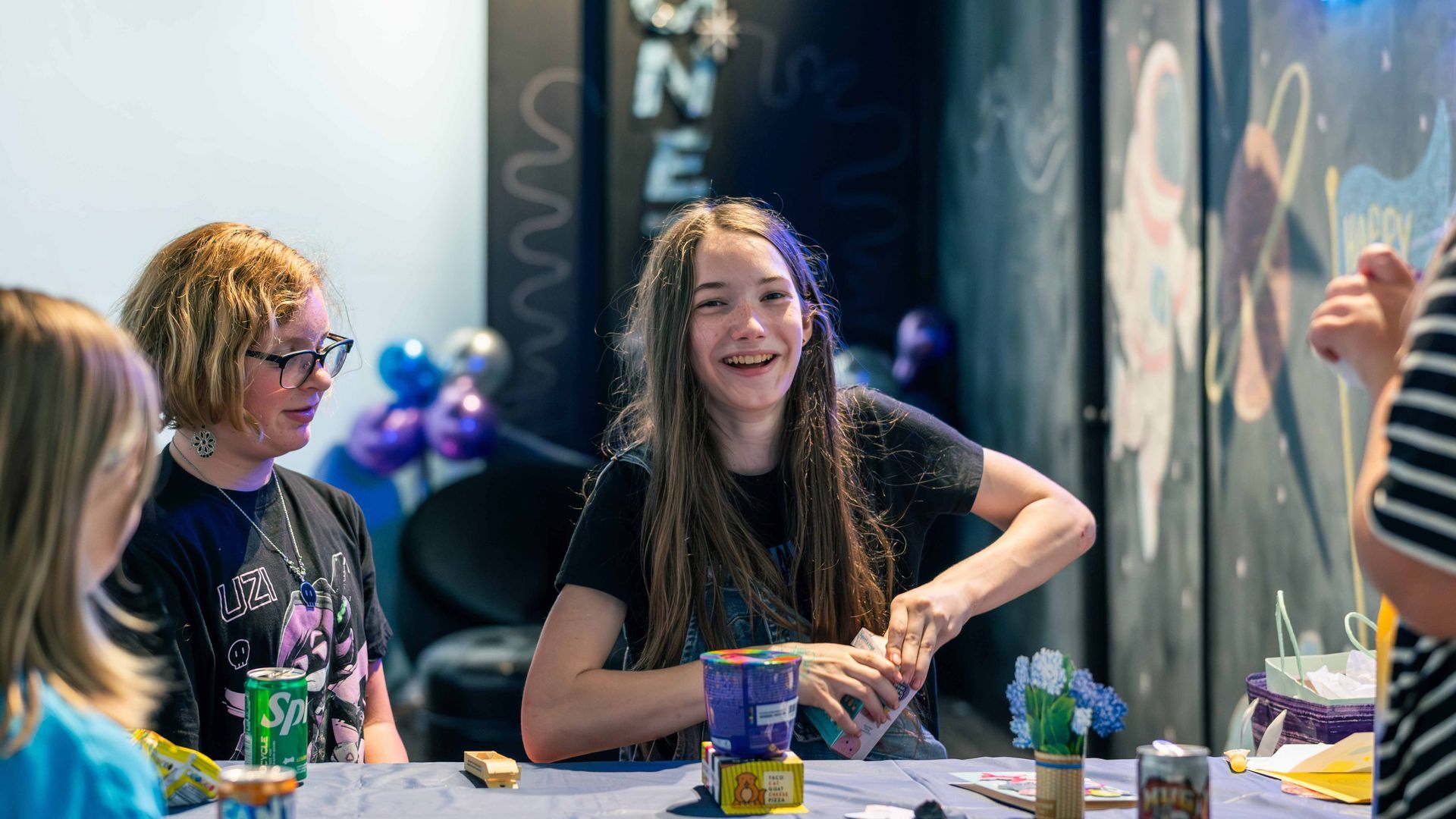 A photo of a 12 year old girl opening a birthday present in the ScienceWorks Celebration Room