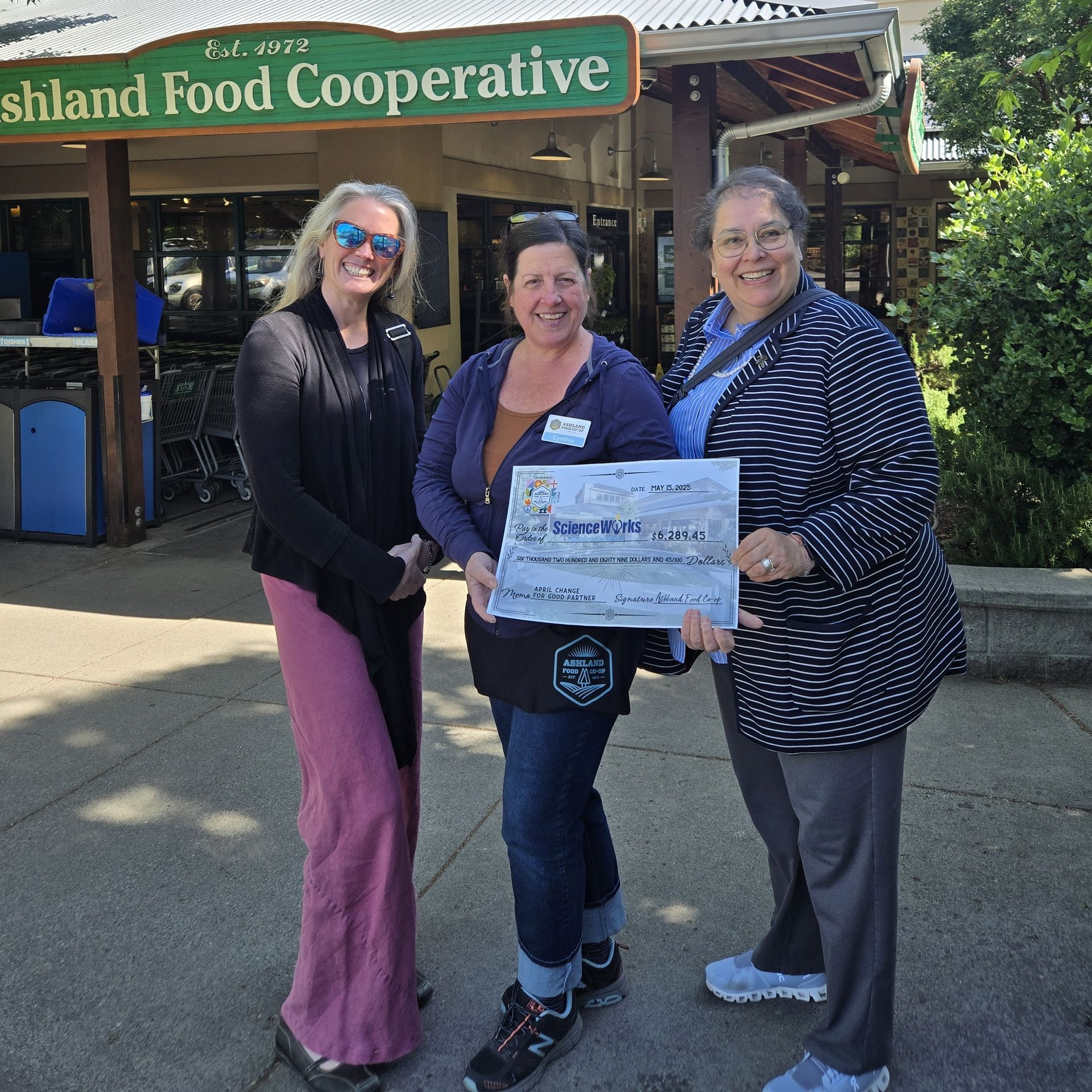 ScienceWorks and Ashland Food Co-op staff pose with a giant sized donation check.