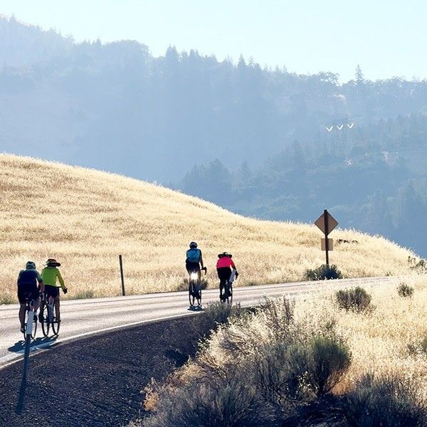 bicyclists riding a twisting road through southern Oregon hills