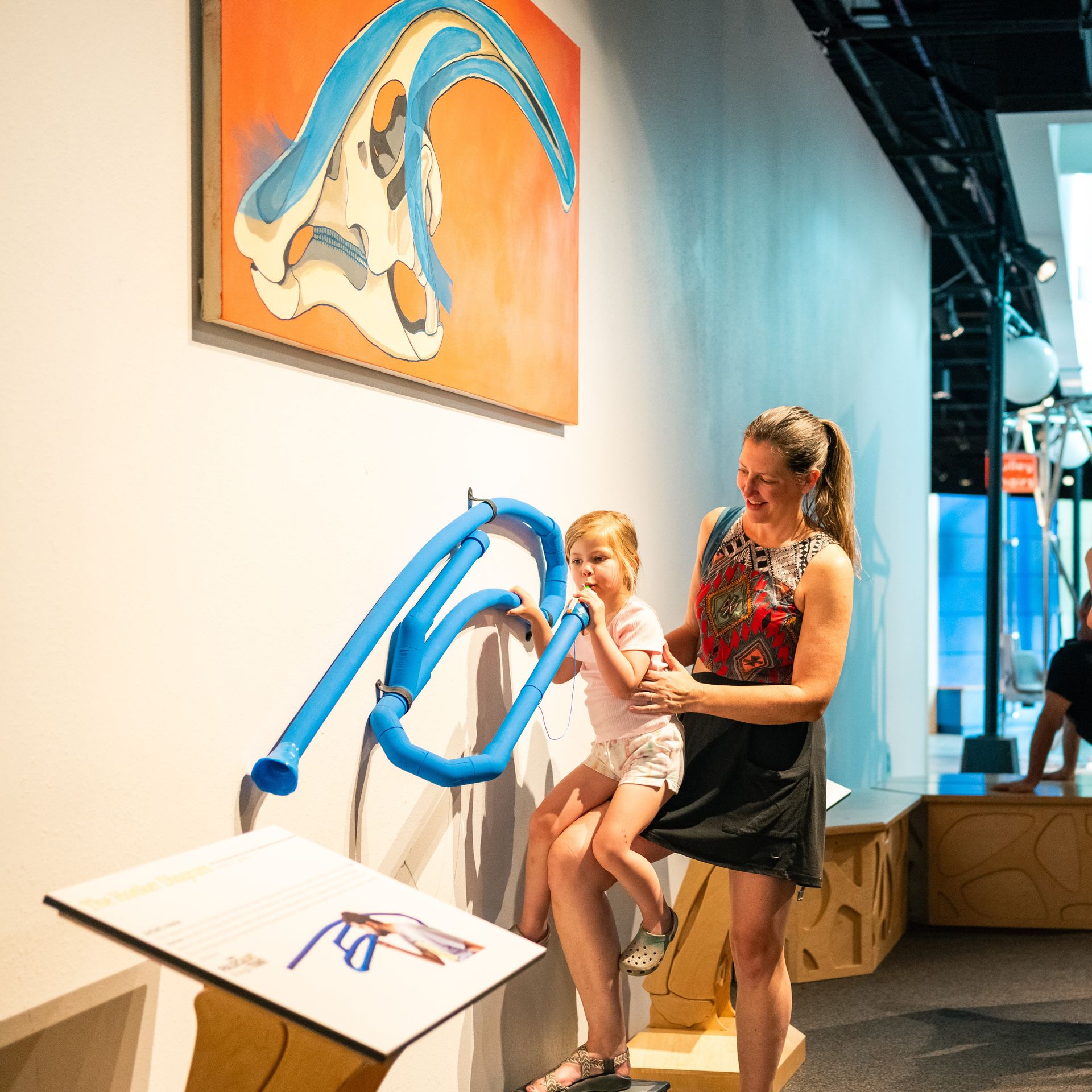 A child and parent interact with a model of the nasal passages of a pterosaur at the paleoart exhibit at ScienceWorks