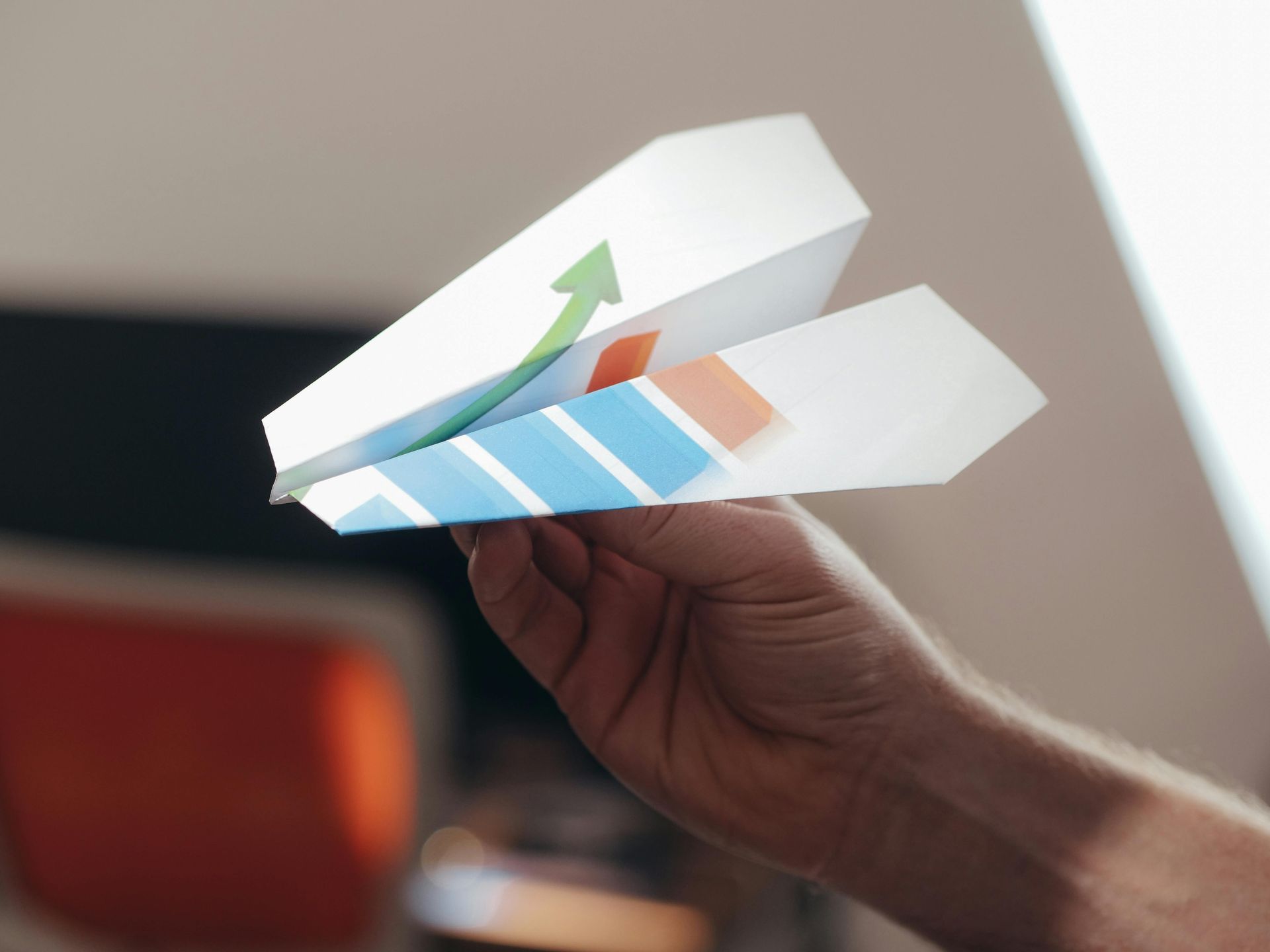 a paper airplane held by a hand
