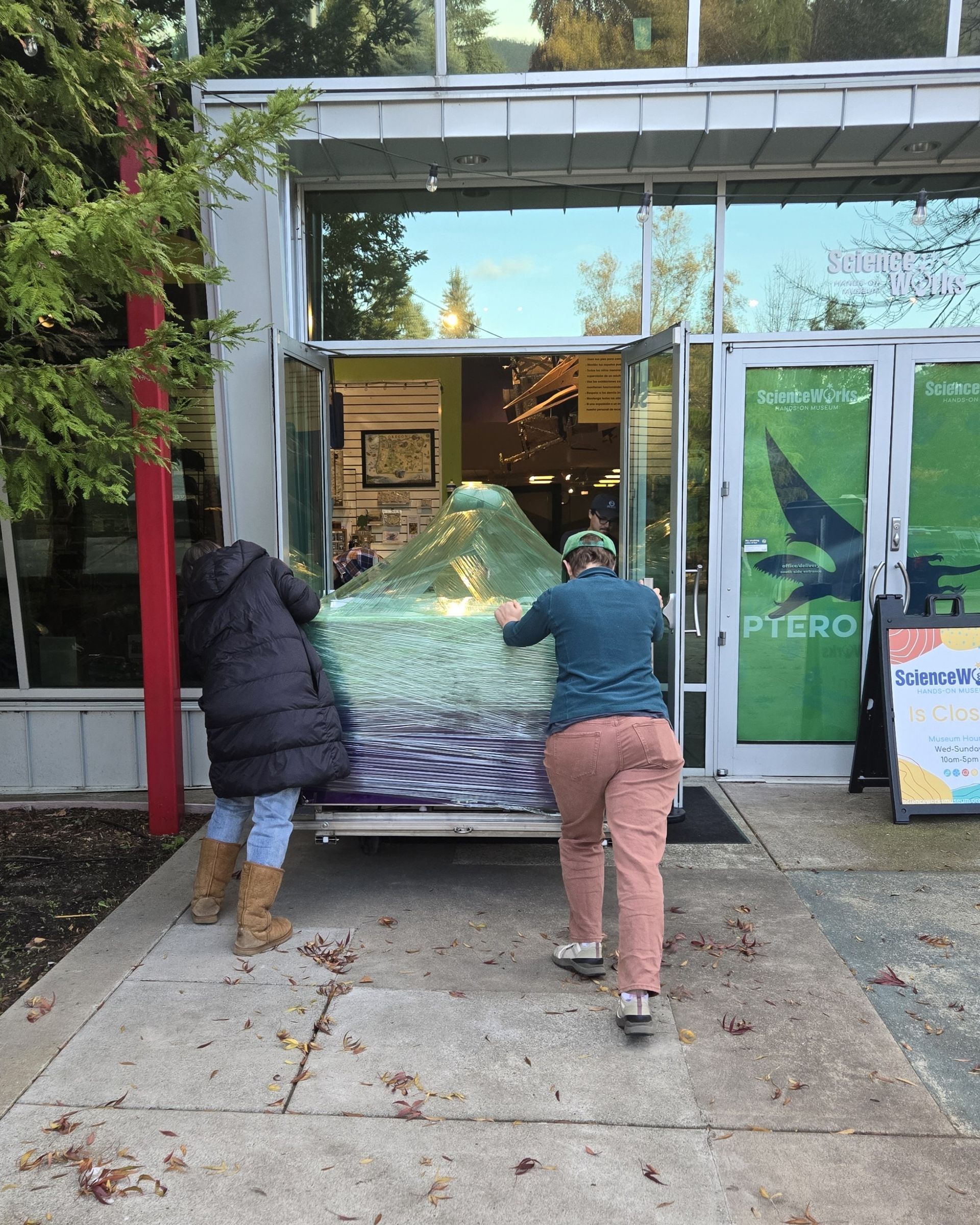 ScienceWorks staff pushing the new water table through the front doors.