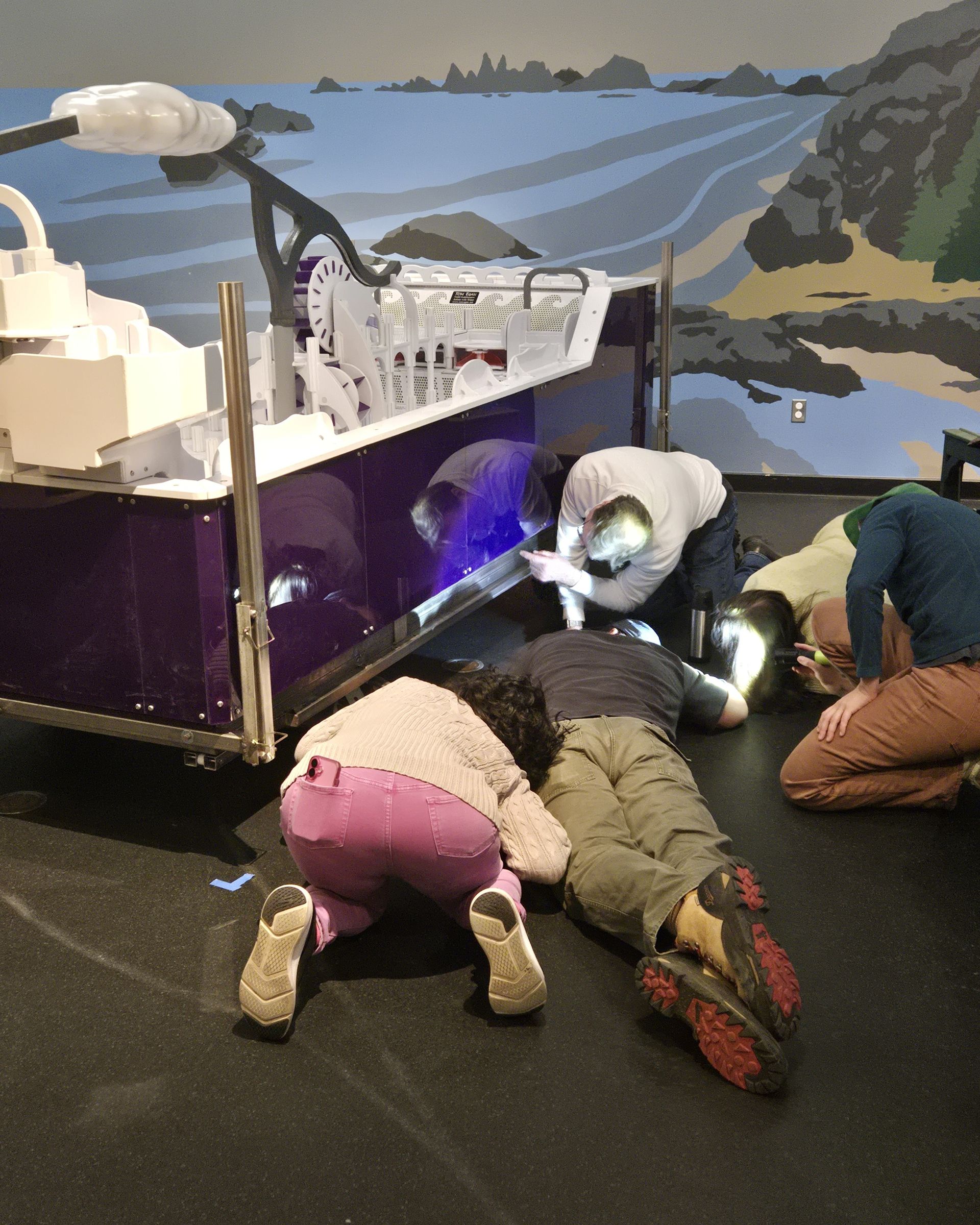 ScienceWorks staff inspecting the underside of the new water table exhibit