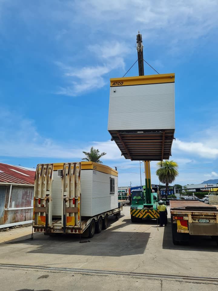 A Crane is Lifting a Container on Top of a Trailer — Bell's Carrying & Crane Hire Service Pty Ltd in Atherton, QLD