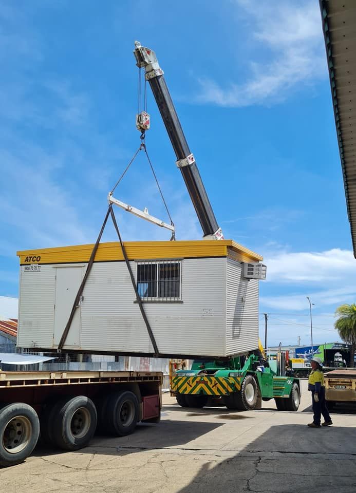 A Crane is Lifting a Building Onto a Truck — Bell's Carrying & Crane Hire Service Pty Ltd in Port Douglas, QLD