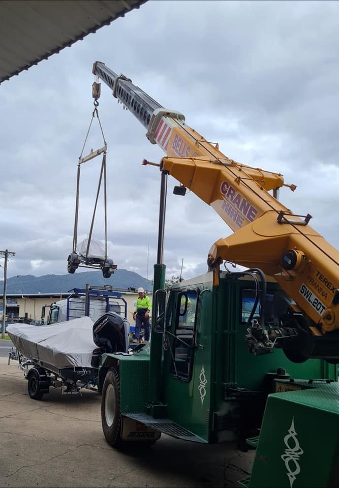 A Crane is Lifting a Boat From a Trailer — Bell's Carrying & Crane Hire Service Pty Ltd in Port Douglas, QLD