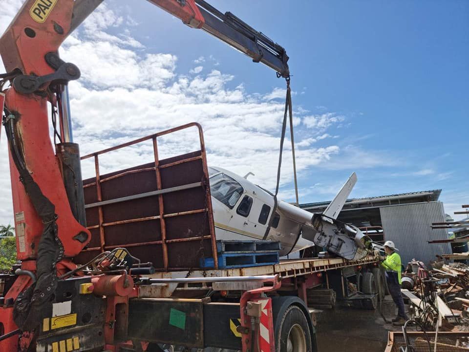 A Crane is Lifting a Plane From the Back of a Truck — Bell's Carrying & Crane Hire Service Pty Ltd in Normanton, QLD