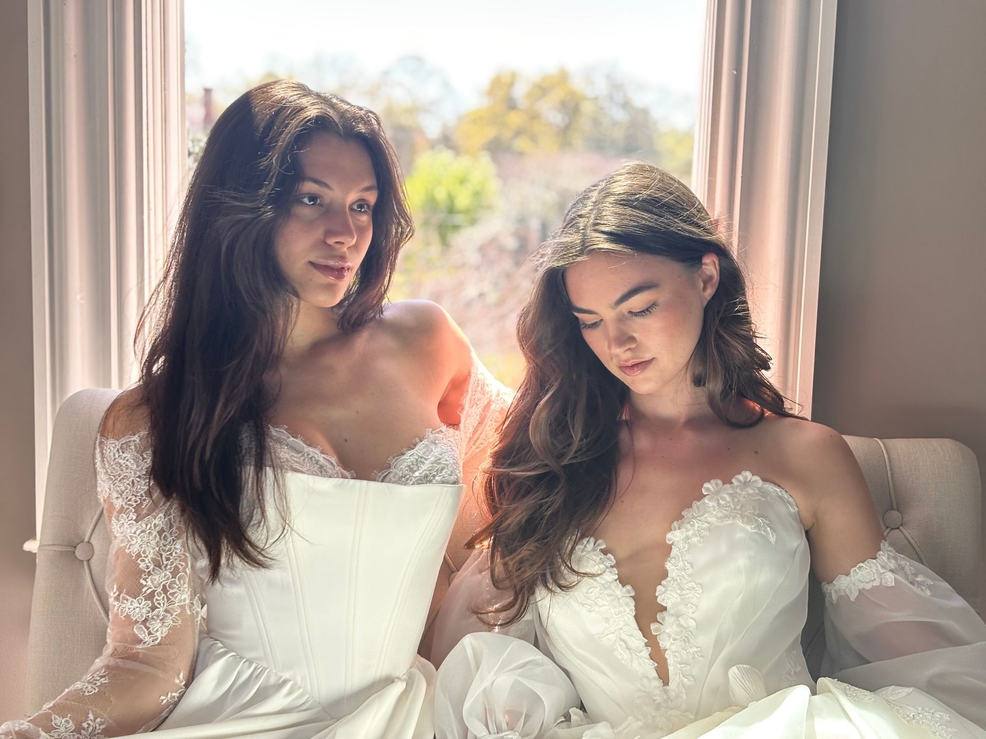 Woman in a strapless white lace wedding dress indoors; train on the floor.