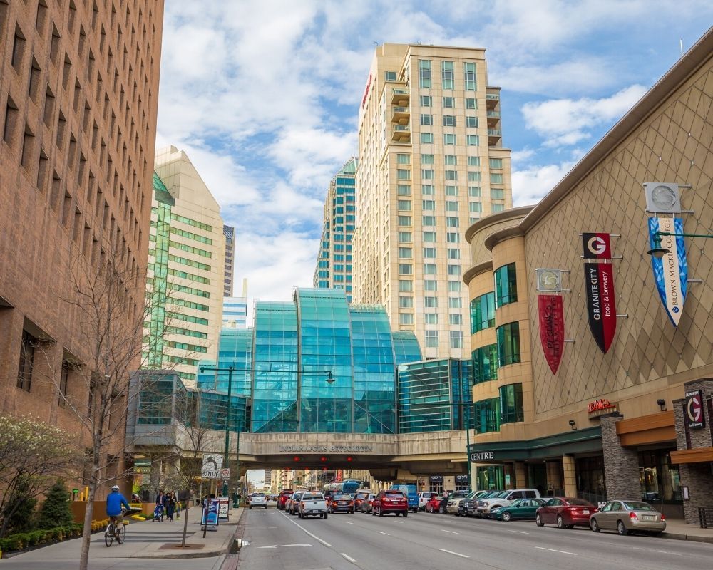 A city street with lots of tall buildings and cars driving down it