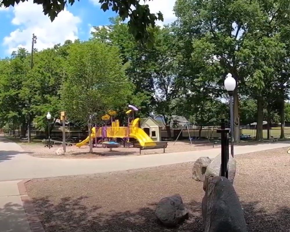 A playground in a park with trees in the background
