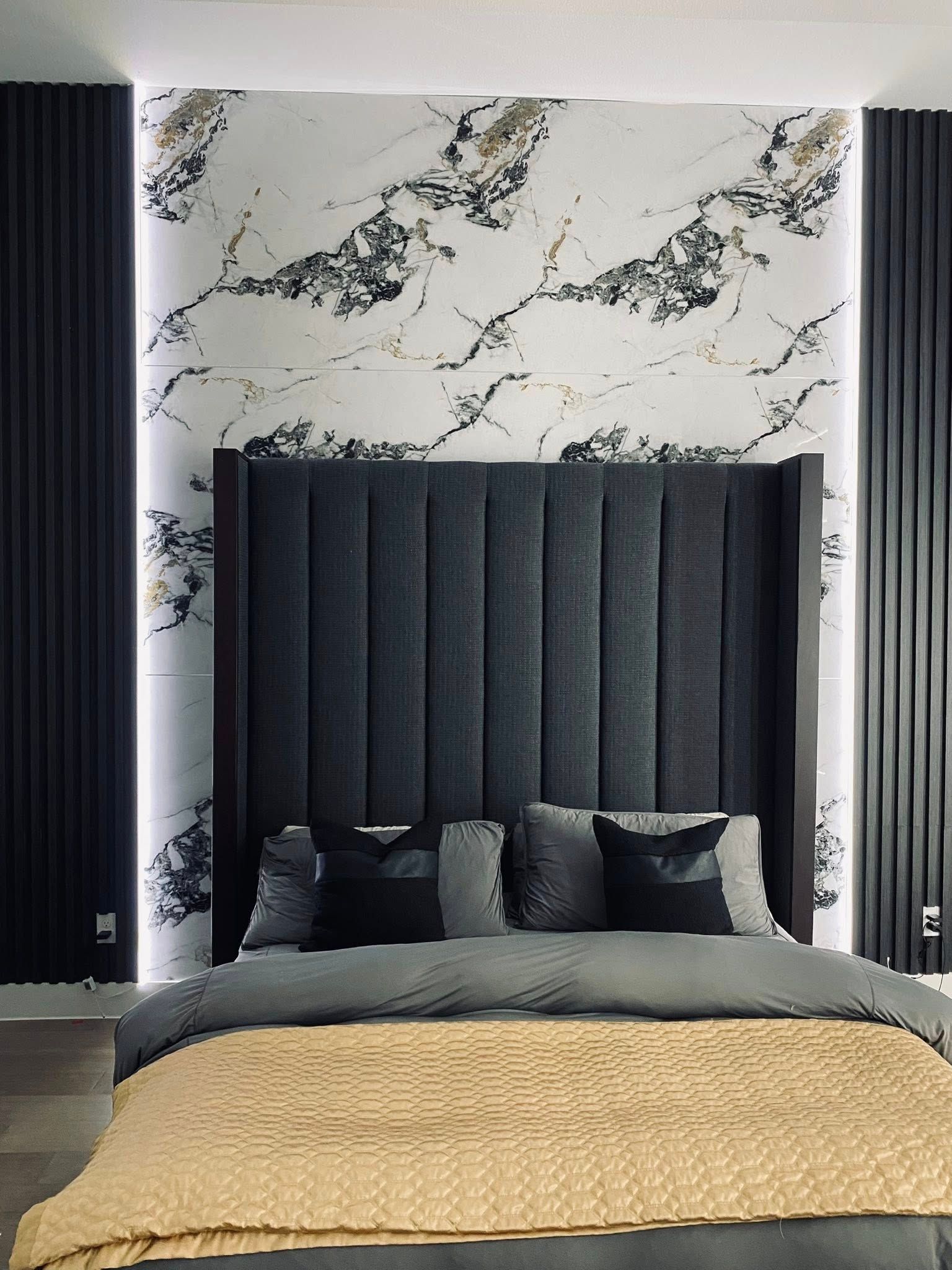 Bedroom with a tall, dark gray headboard, marble wallpaper, and black paneling with LED lights.