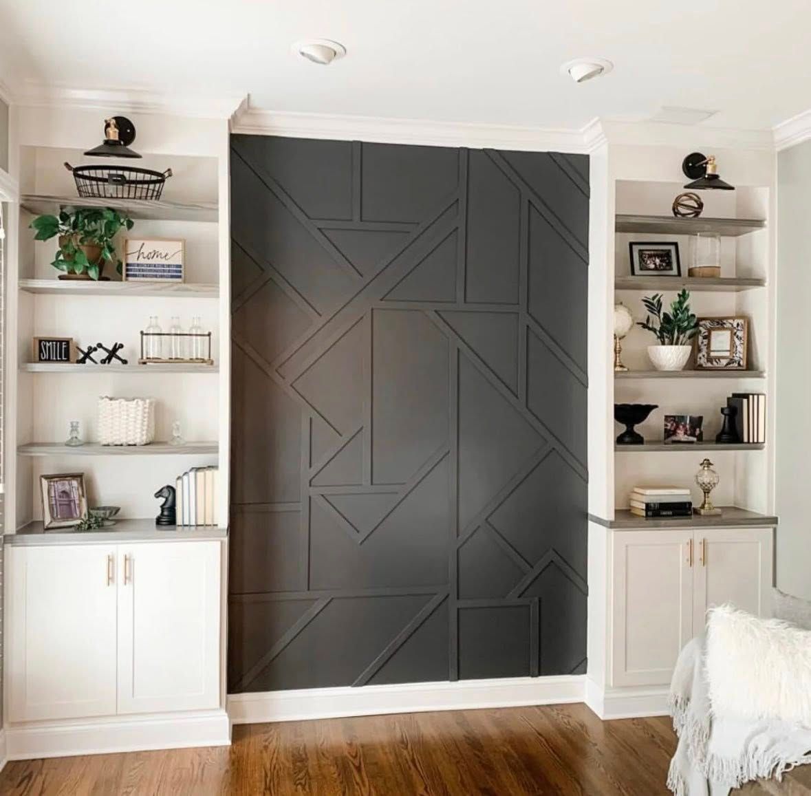 Built-in bookshelves flank a geometric dark gray accent wall.