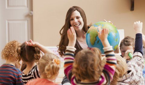 Teacher showing the globe to kids
