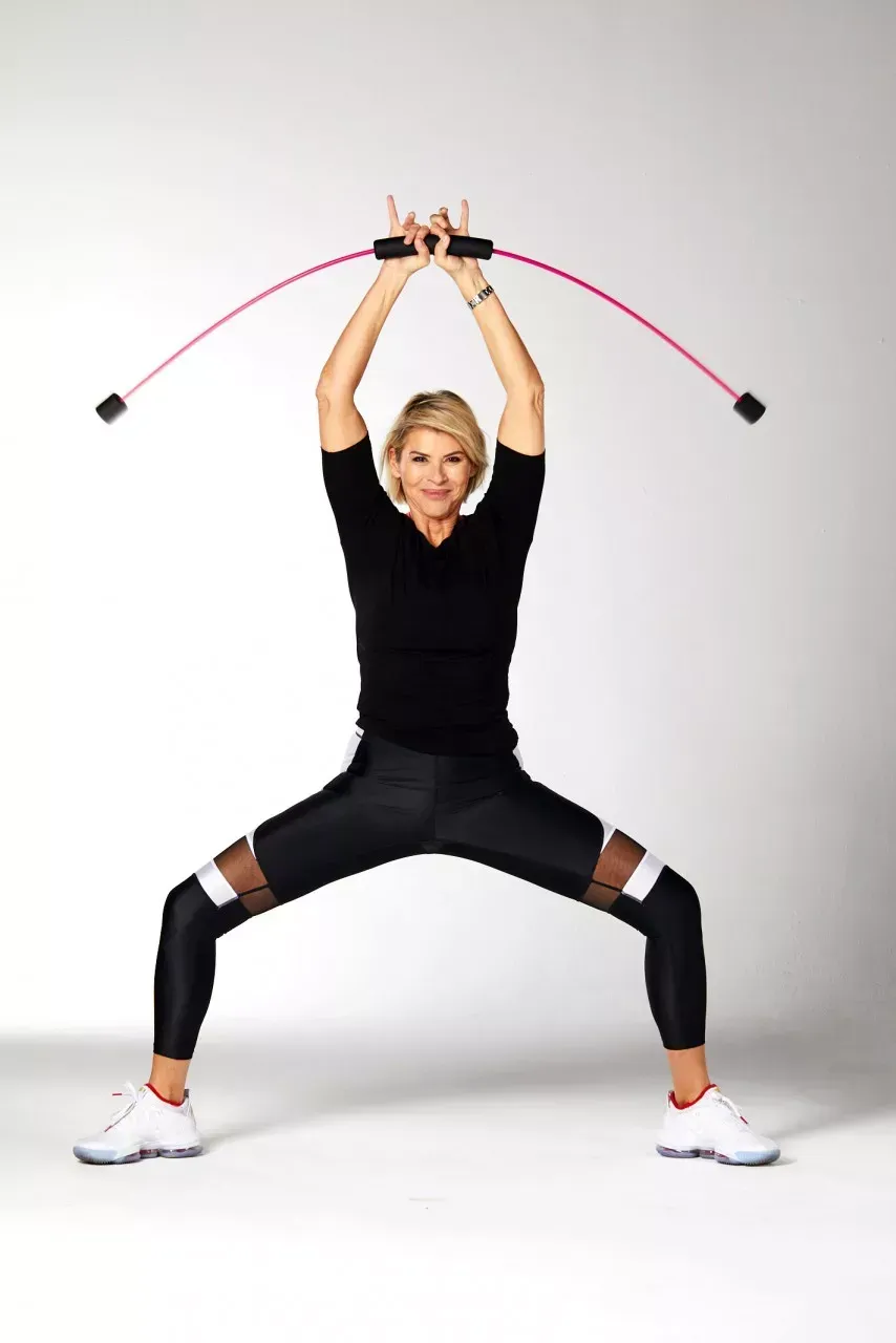 Eine Frau macht Übungen mit einem Widerstandsstab.