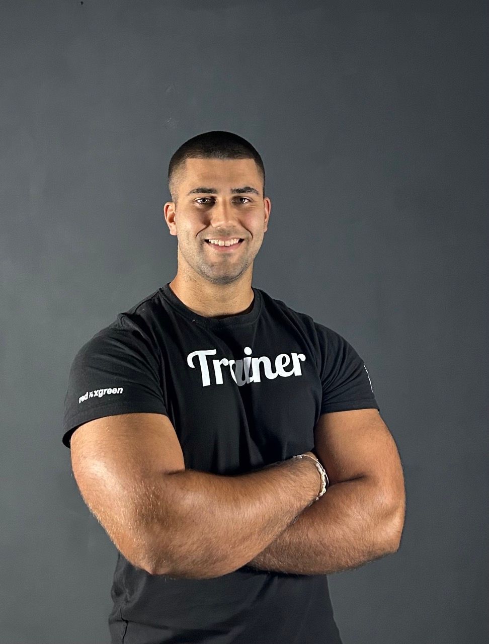 Ein Mann trägt ein schwarzes Hemd mit der Aufschrift „Trainer“ darauf