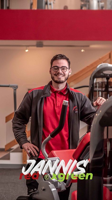 Ein Mann steht neben einem Gerät in einem Fitnessstudio.