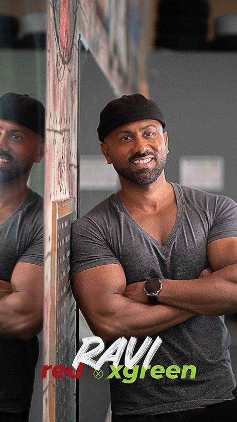 Ein Mann steht mit verschränkten Armen vor einem Spiegel.