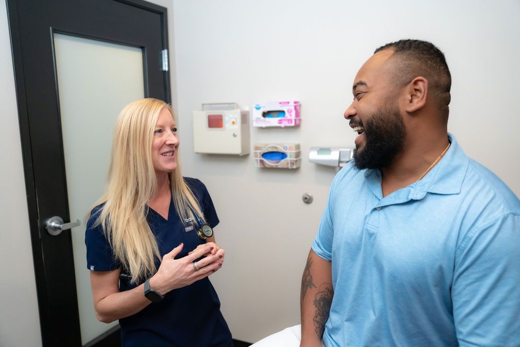 Cora Mattie talking with a male patient in a clinic hallway