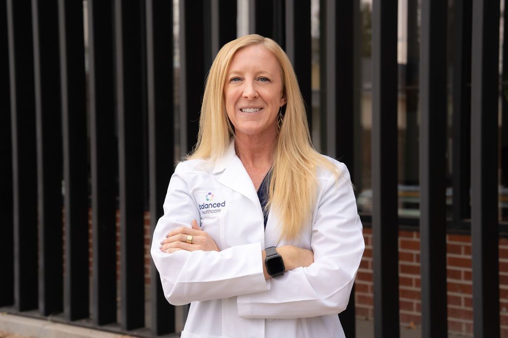 Cora Mattie in a white coat, standing outside with arms crossed