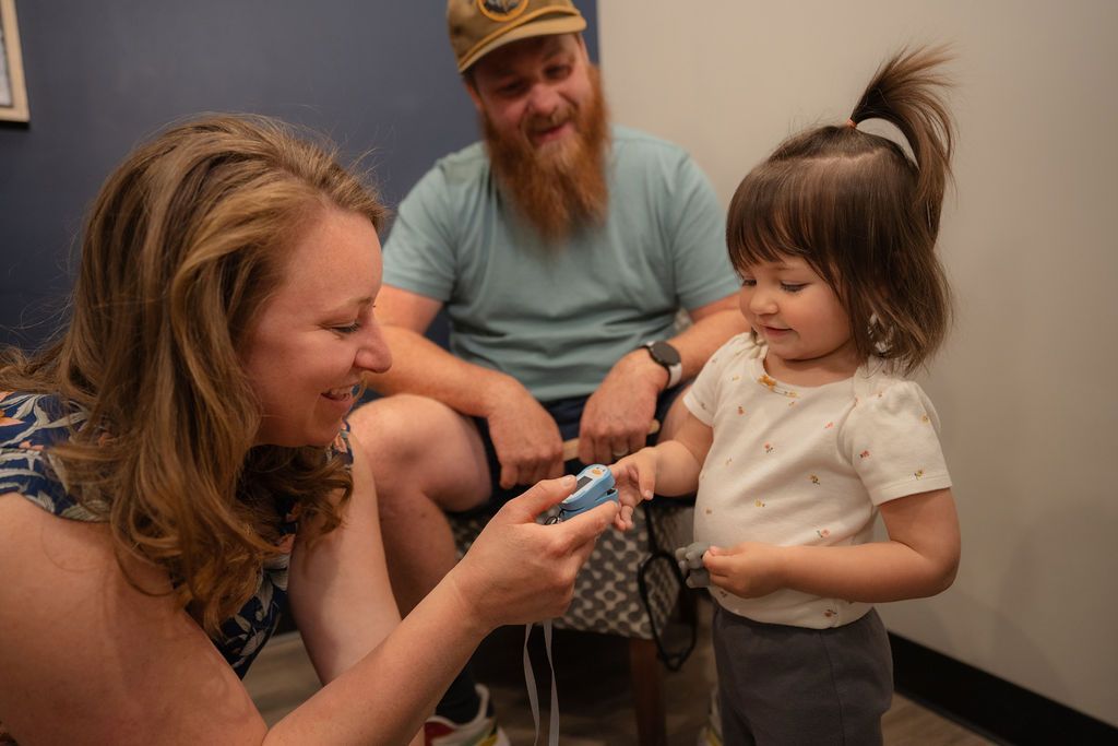 Balanced Healthcare staff checking a child's pulse with an oxometer