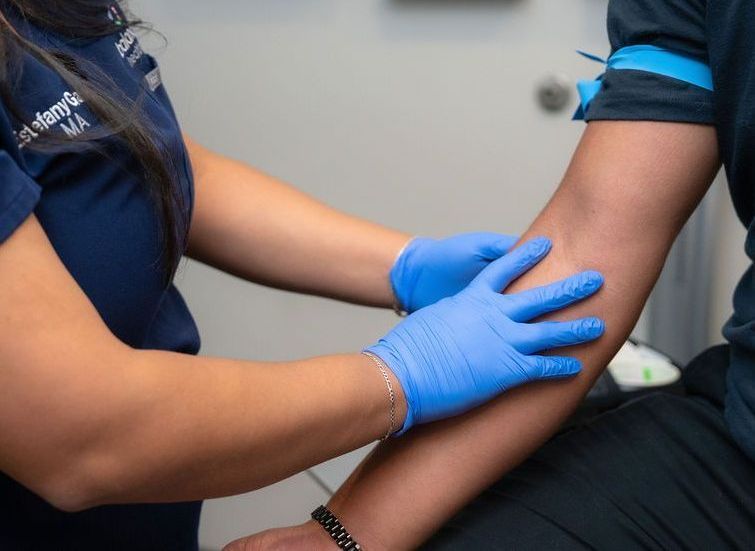 Balanced Healthcare provider checking a male patient's reflex