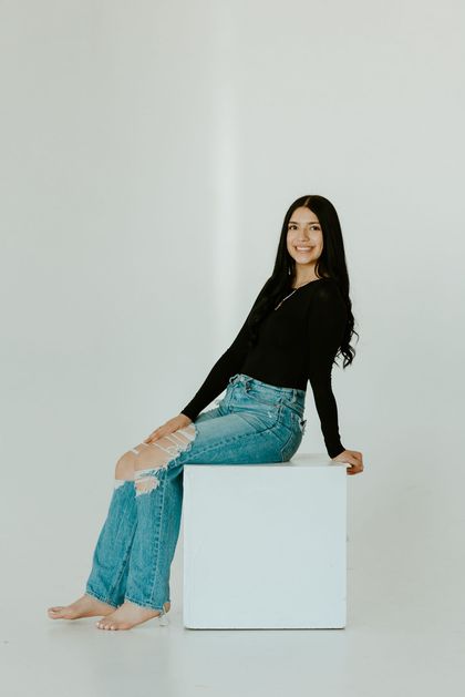 Joanna posing indoors against a light background in casual attire
