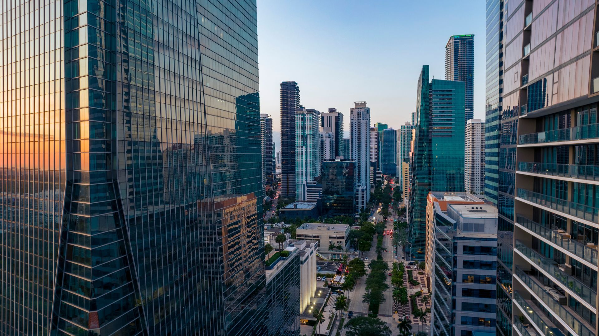 An aerial view of a city skyline at sunset with lots of tall buildings.