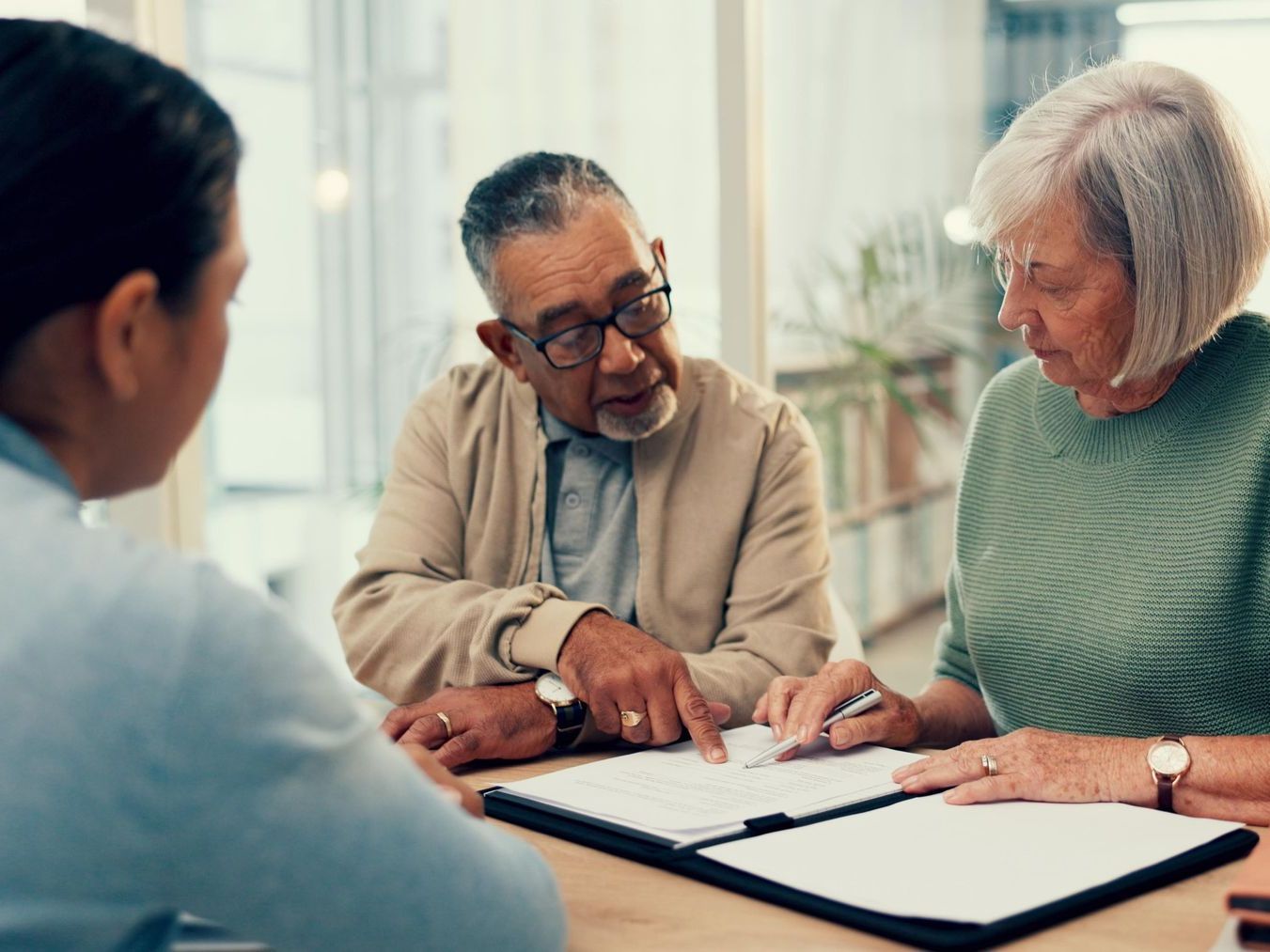 A man and a woman are sitting at a table signing a document.