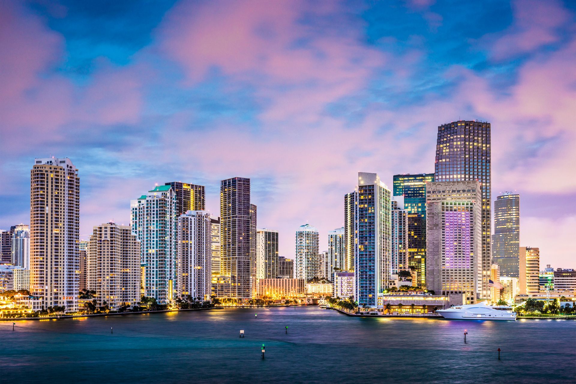 A city skyline overlooking a body of water at night.