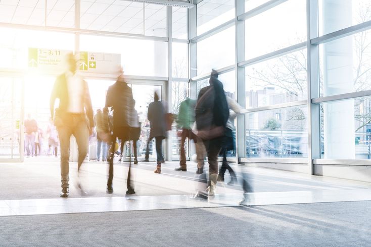A blurry picture of a group of people walking through a building.