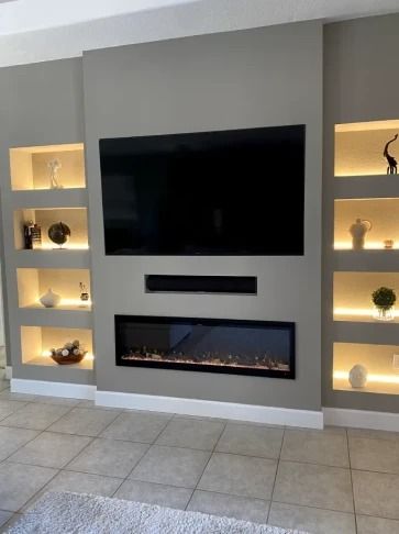 Modern living room wall with mounted TV and linear fireplace, flanked by lit display shelves.