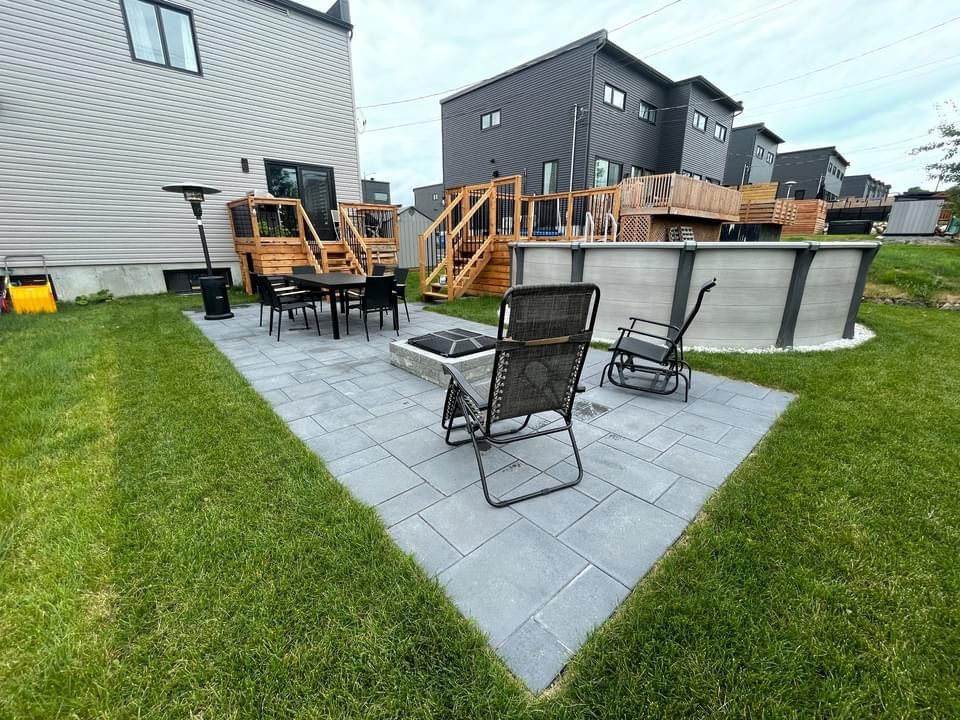 Terrasse arrière avec foyer, sièges, piscine hors sol et maisons modernes.