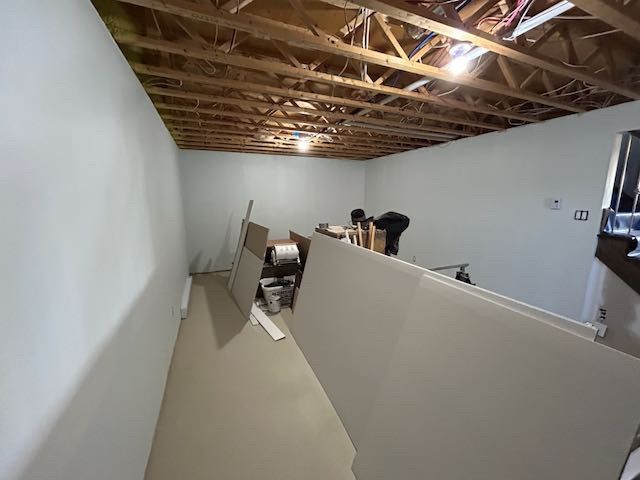 Pièce avec sol et murs en plaques de plâtre, plafond non fini et matériaux de construction ; intérieur.