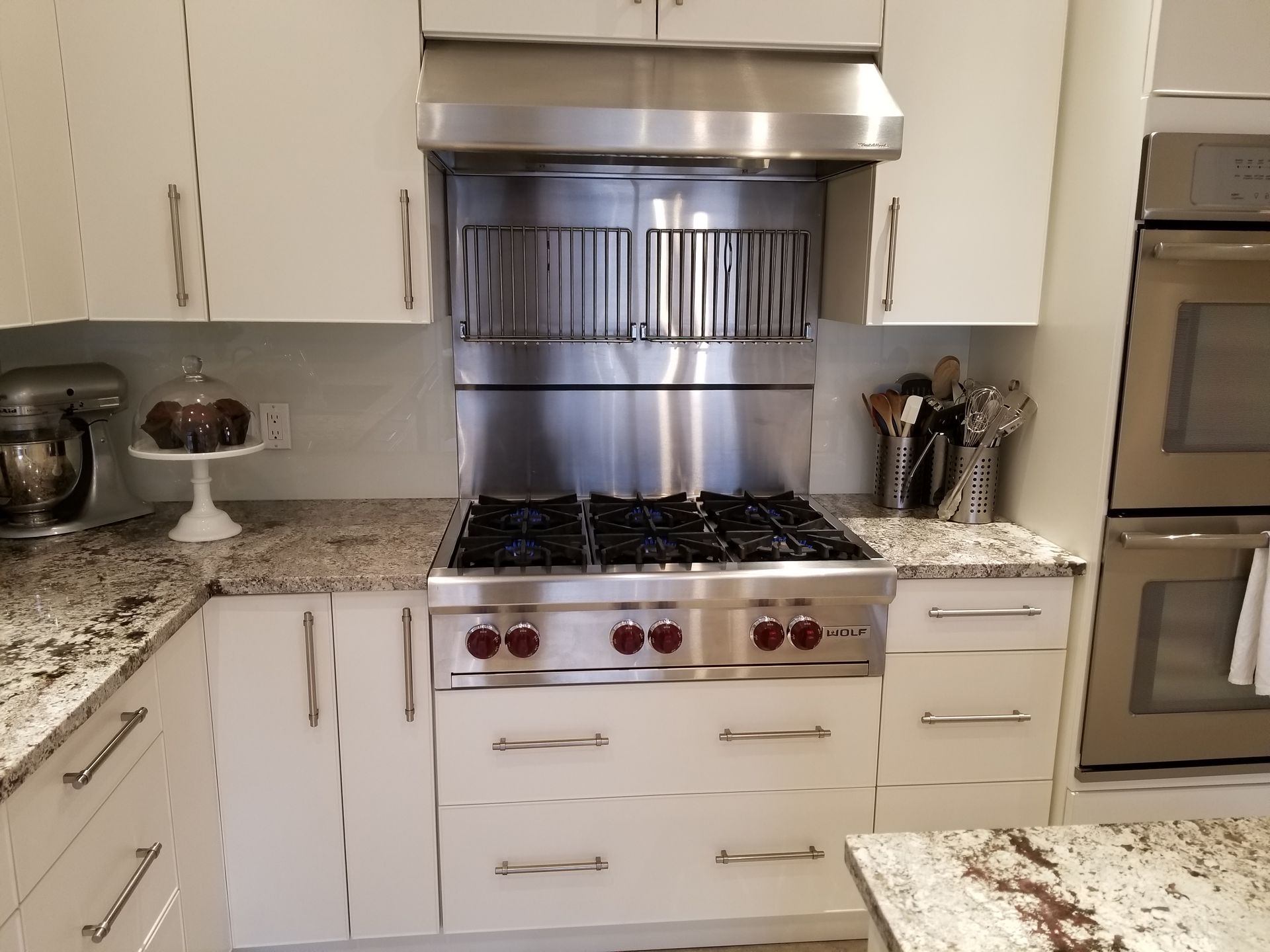 A kitchen with stainless steel appliances and white cabinets