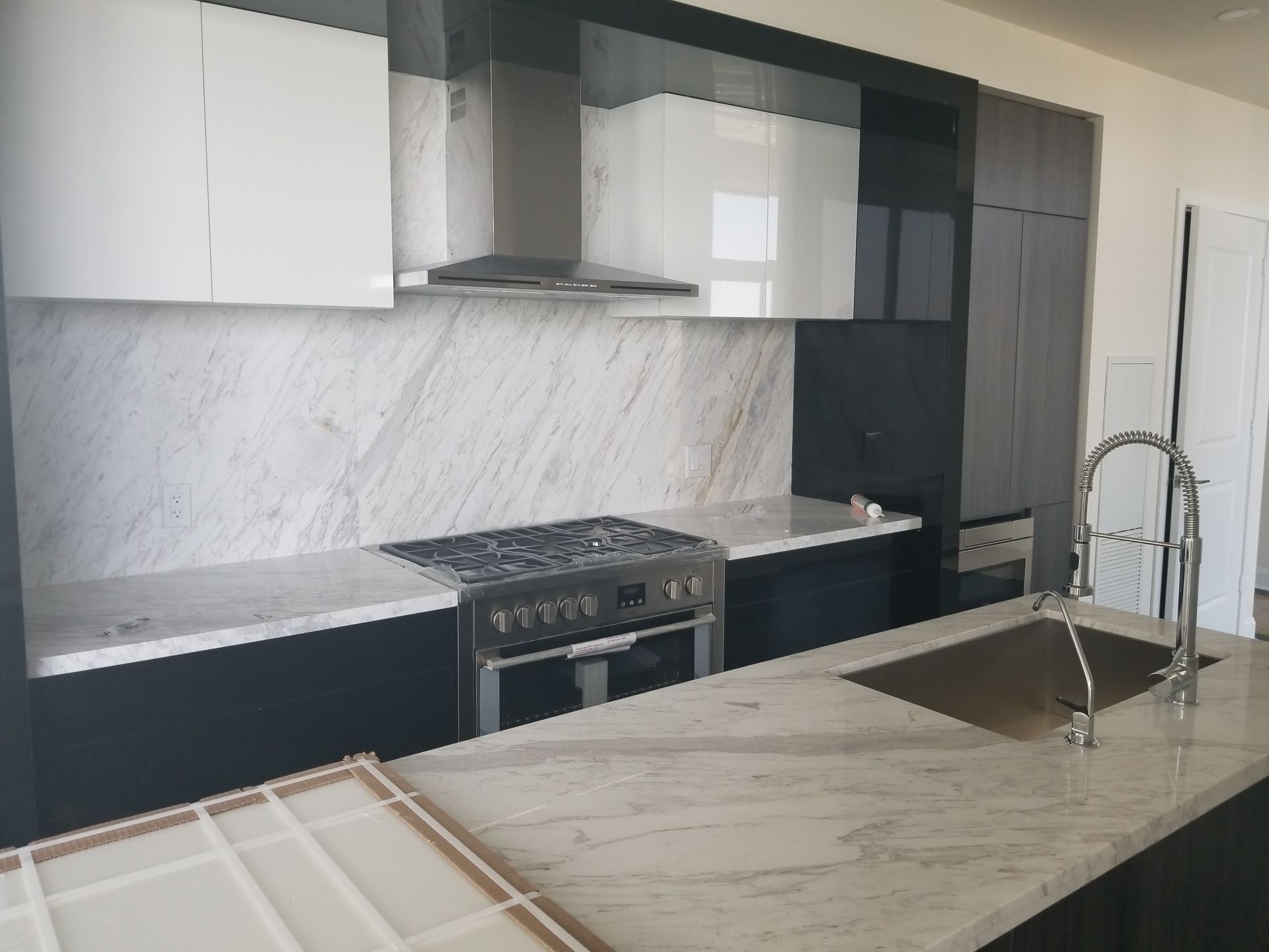 A kitchen with a stove top oven and a sink