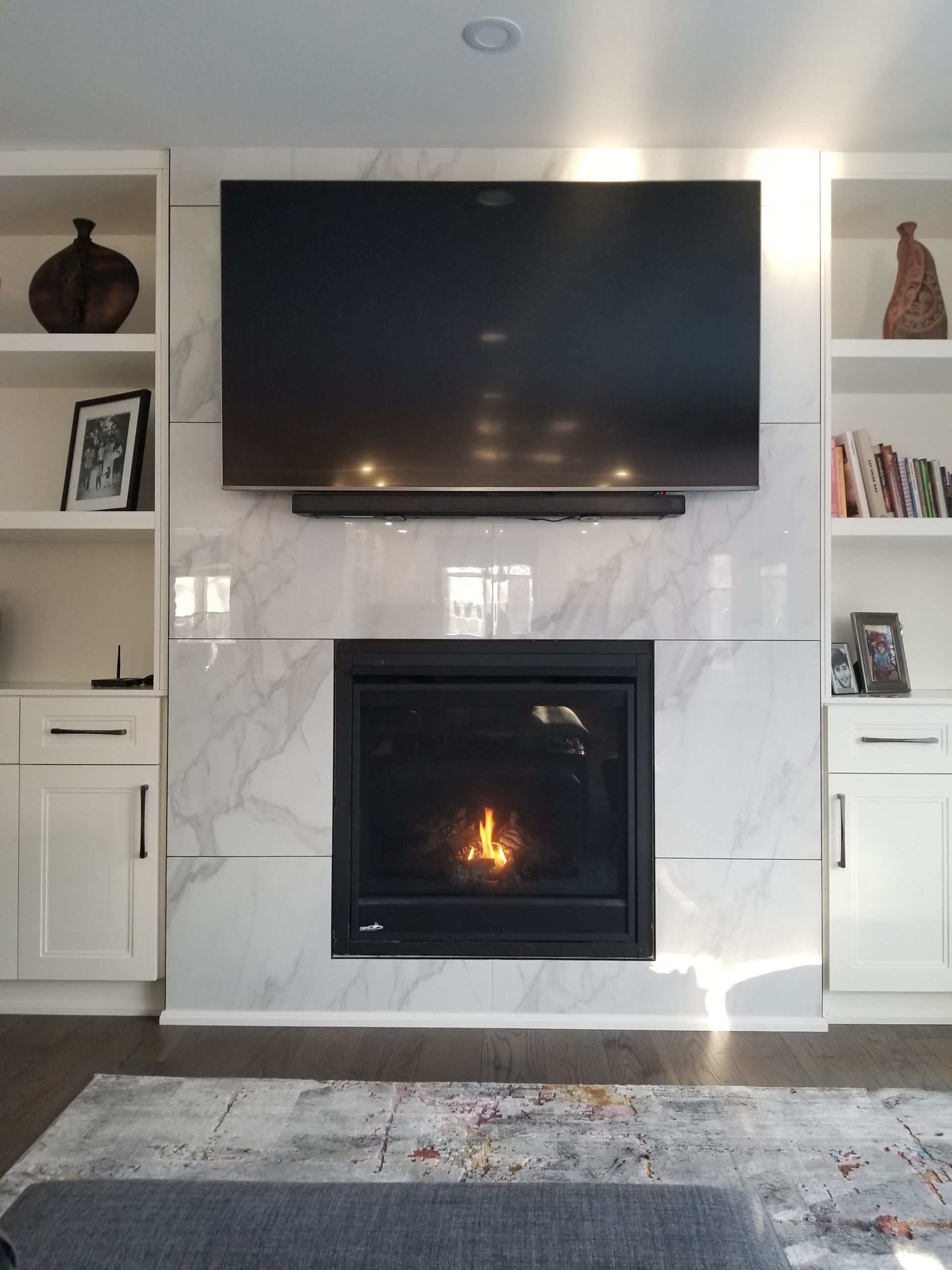A living room with a fireplace and a flat screen tv