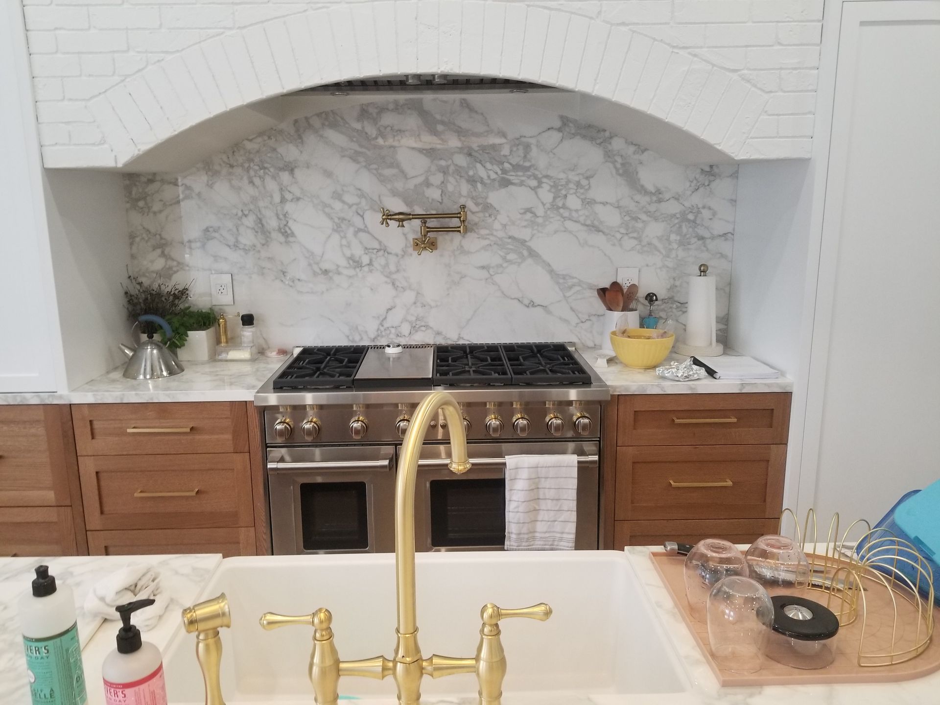 A kitchen with a sink , stove , and oven.