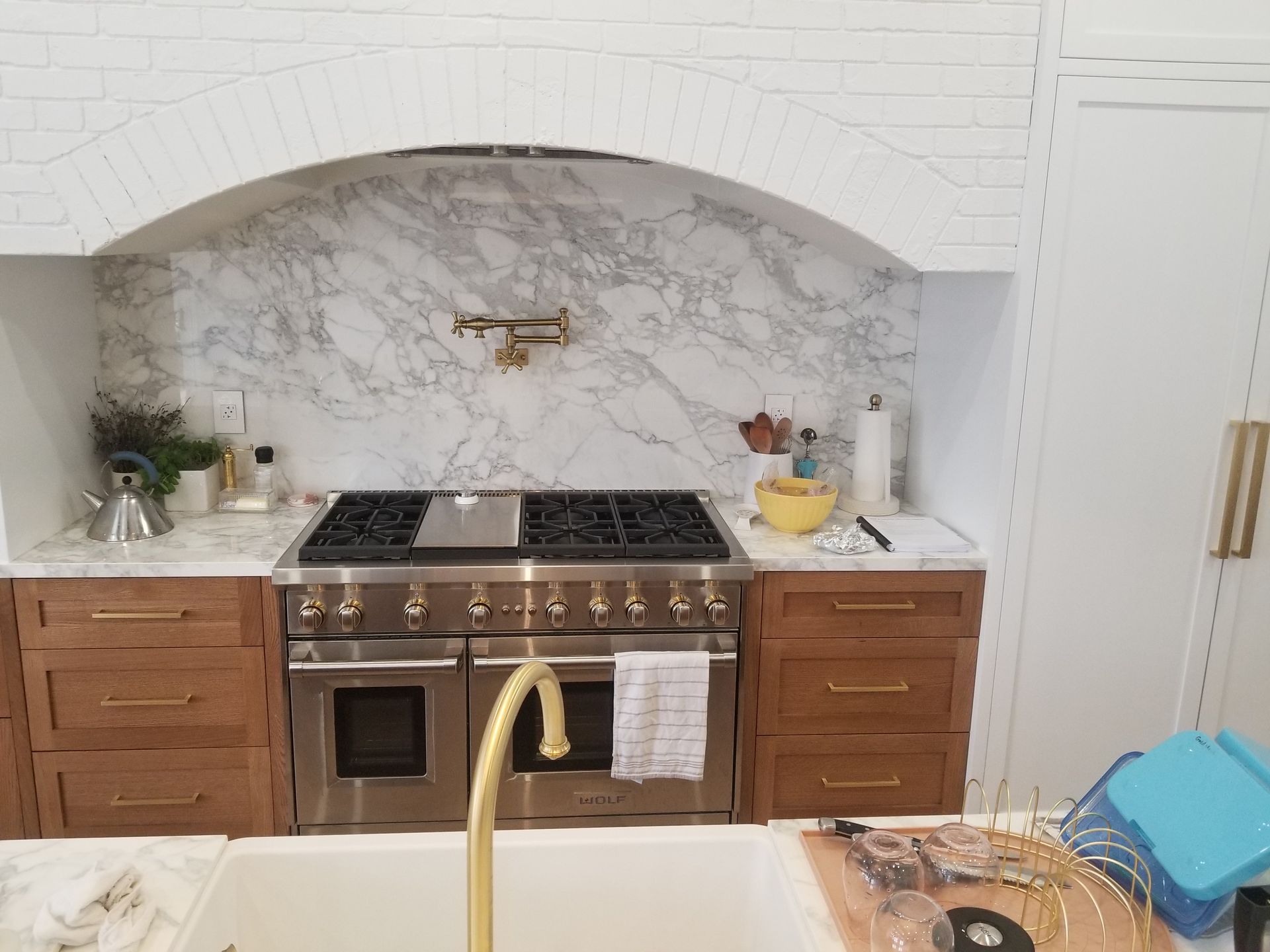 Modern kitchen with a gas stove and marble backsplash.