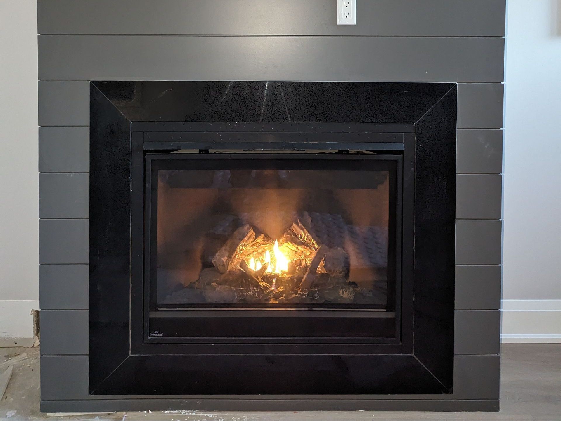 a fireplace with a flame coming out of it in a living room .
