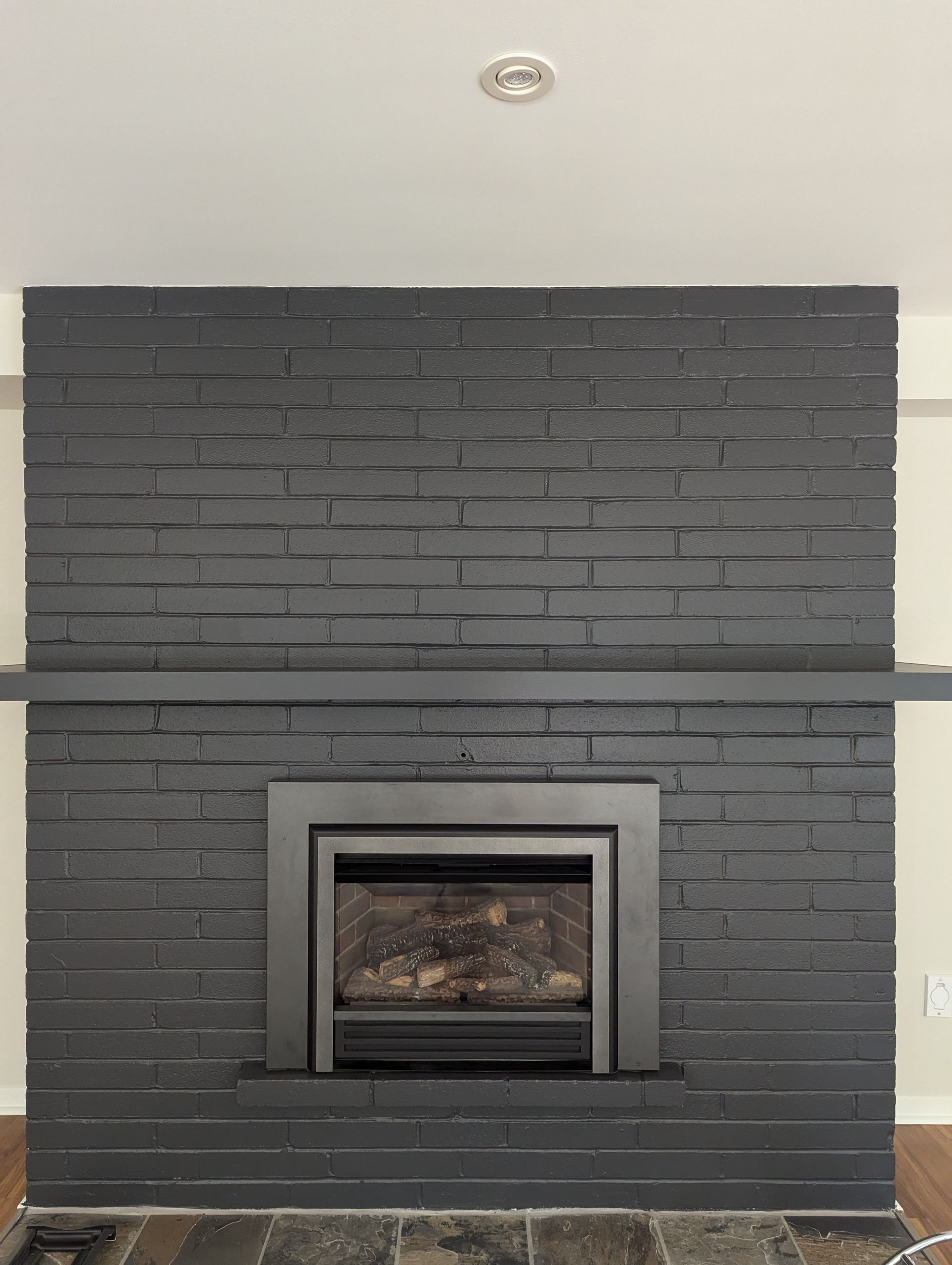 Black brick fireplace with a modern insert.
