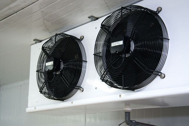 two fans are hanging from the ceiling of a room