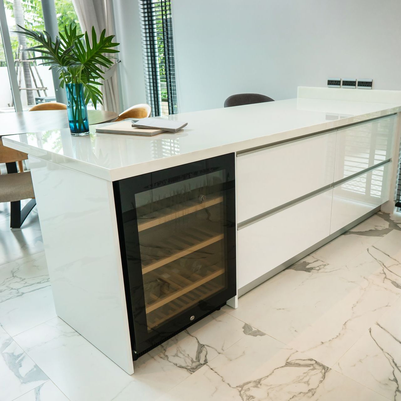 a kitchen island with a wine cooler underneath it