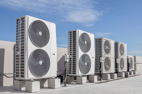 a row of air conditioners are sitting on top of concrete blocks .
