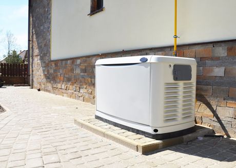 a white generator is sitting on the side of a house .