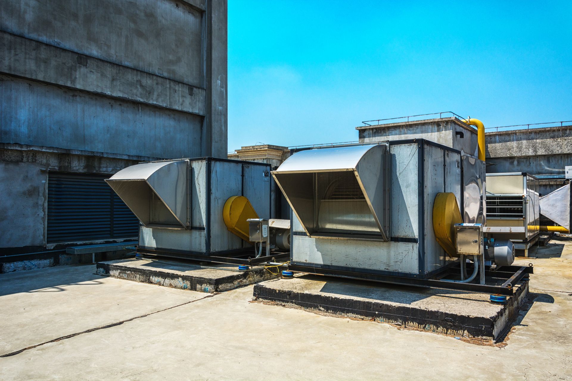 Industrial HVAC ventilation units on a building rooftop.