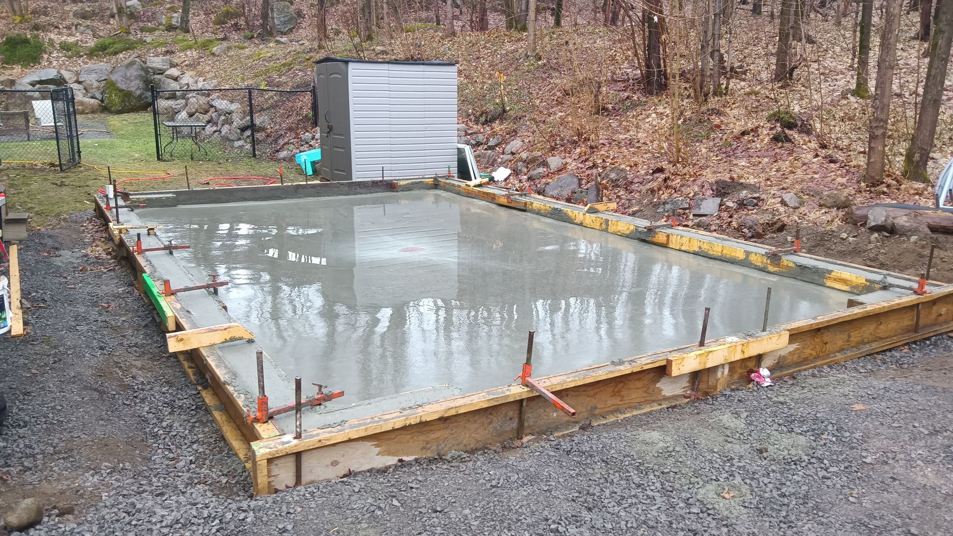 Dalle de béton fraîchement coulée dans un cadre en bois, en extérieur.